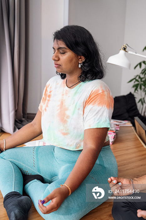 Group of friends meditating and doing yoga at home