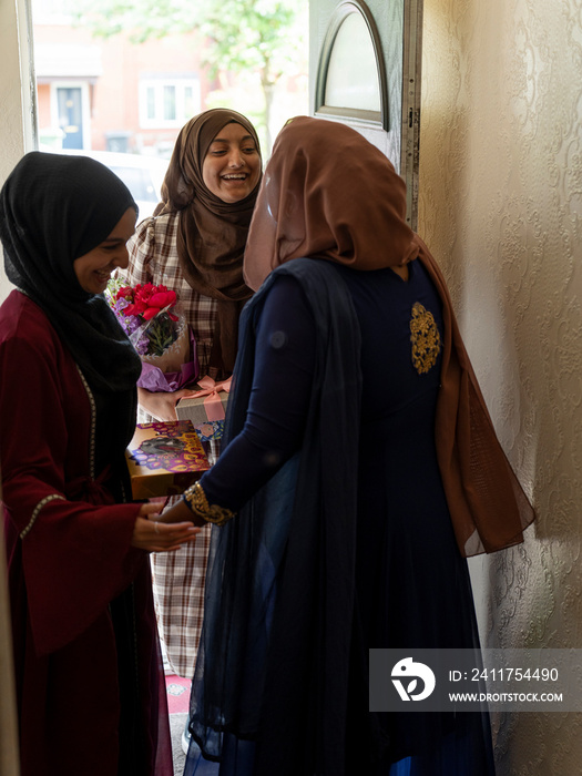 Woman greeting friends at home during Ramadan