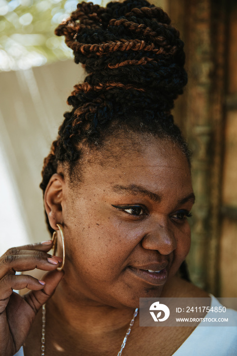 portrait of a plus size afro latinx haitian american with top knot looking away