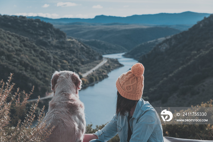 Young girl traveling by nature with backpack and dog