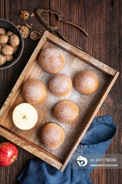 Sweet baked buns with apple and walnut filling, sprinkled with powdered sugar