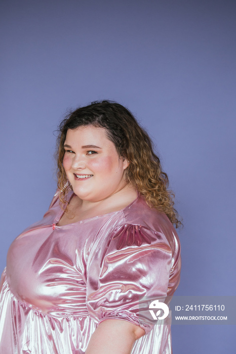 portrait of a plus size woman wearing a pink shiny dress