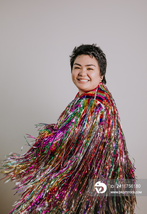 portrait of a plus sized woman wearing a tinsel jacket smiling