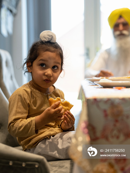 Portrait of boy in traditional clothing eating food