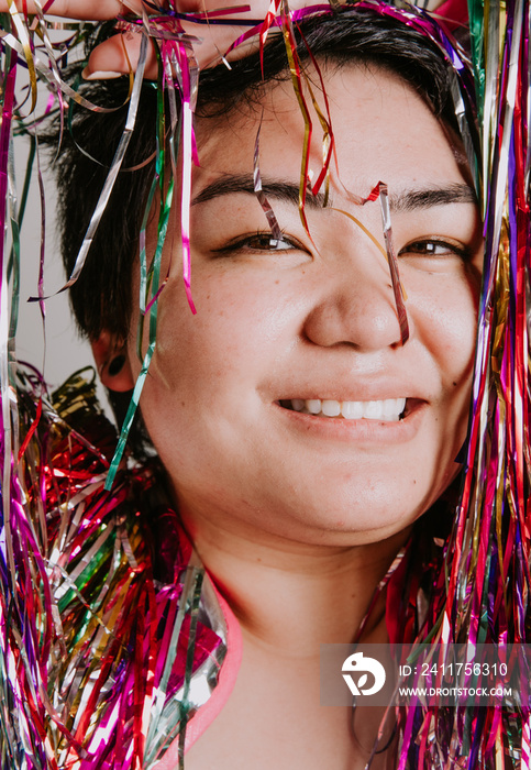 closeup of a plus size filipino woman surrounded by tinsel