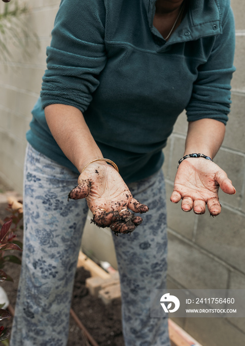 South Asian woman gardening in backyard