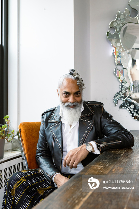 portrait of man with gray beard wearing leather jacket and skirt