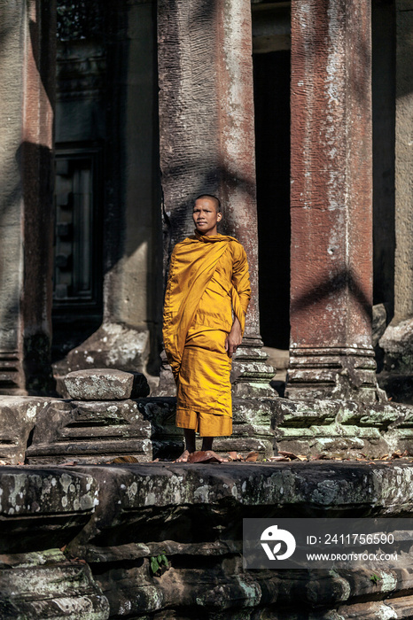 Young Buddhist monk praying outside temple in Angkor Wat, Siem Reap, Cambodia