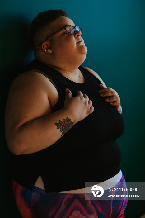 portrait of a plus size person leaning against wall