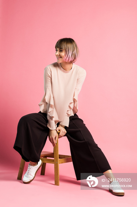 Smiling woman sitting on stool