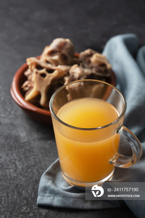 Homemade Beef Bone Broth in Glass Storage Jar on a black background. Dark Style