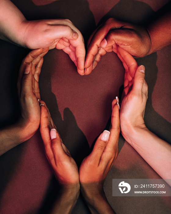 Shot from above of female hands making a big heart shape with their hands