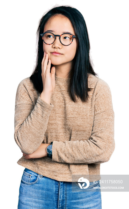 Young chinese woman wearing casual sweater and glasses with hand on chin thinking about question, pensive expression. smiling and thoughtful face. doubt concept.