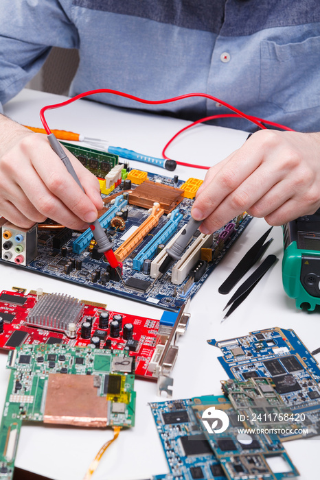 Engineer checking motherboard with multimeter