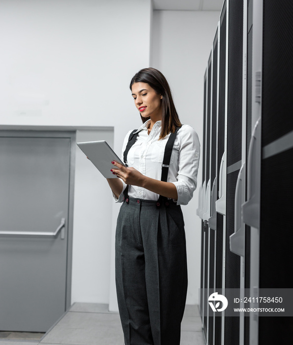 Portrait of technician working on laptop in server room