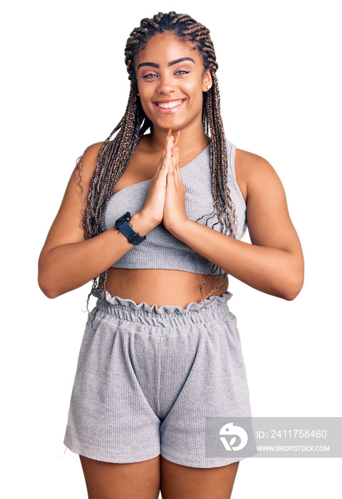 Young african american woman with braids wearing sportswear praying with hands together asking for forgiveness smiling confident.