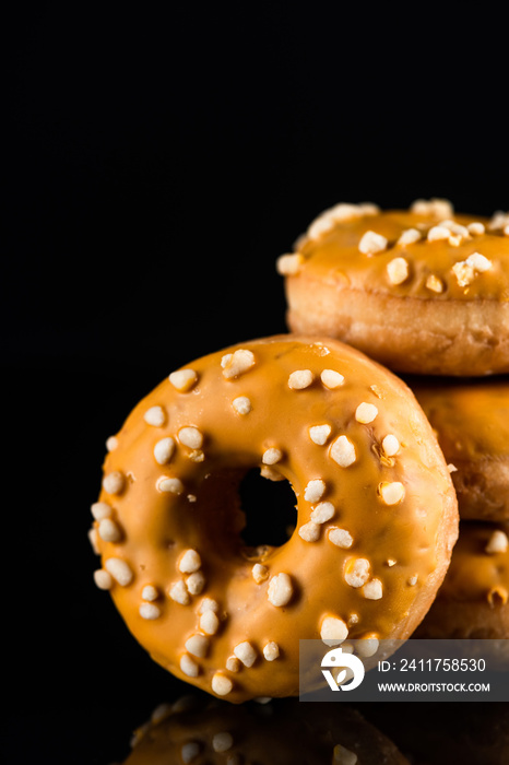 Salted Caramel Donuts or Doughnuts Tower on Dark Background. Copy Space for Text