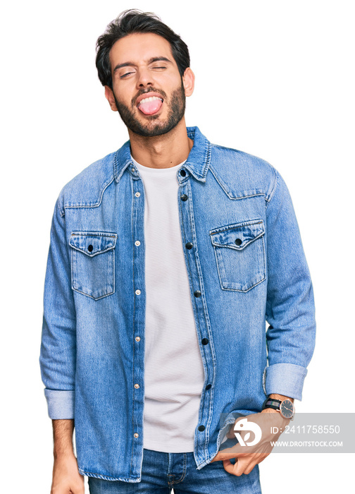 Young hispanic man wearing casual clothes sticking tongue out happy with funny expression. emotion concept.