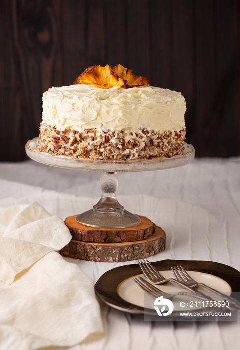 Homemade Hummingbird Cake Decorated with Cream Cheese Frosting and Pecans in a Rustic Environment with Copy Space