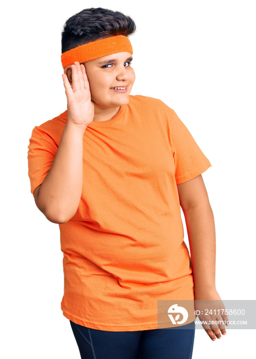 Little boy kid wearing sportswear smiling with hand over ear listening an hearing to rumor or gossip. deafness concept.