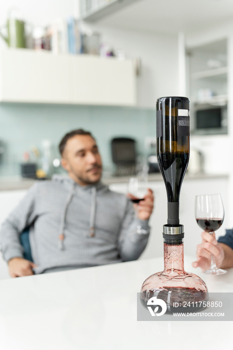 Male couple using wine breather decanter at home