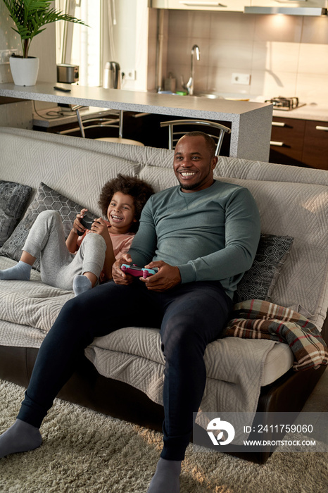 son with open mouth and father playing video game