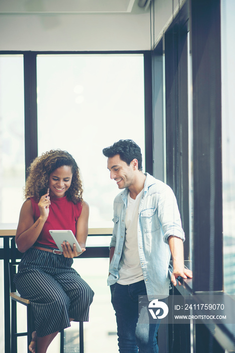 Businesswoman and businessman looking at tablet together