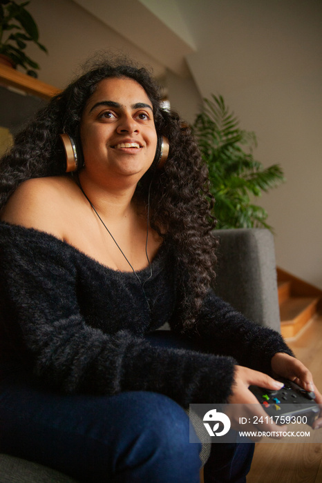 Young Indian woman with curves and Cerebral Palsy playing video games at home