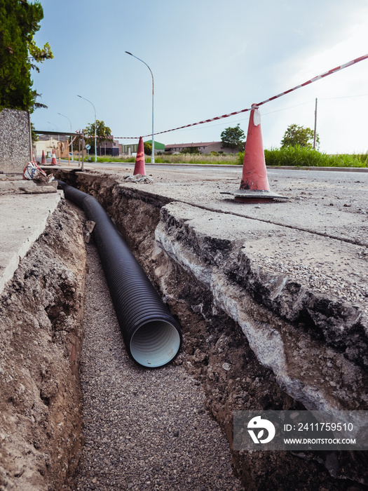 Ditch with new water pipes in the ground of a residential street.