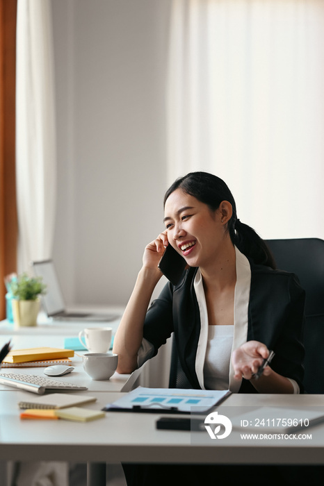 Portrait of confident businesswoman talking on mobile phone with her business partner.