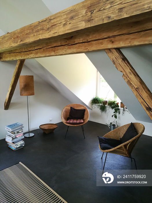 Korbsessel im Design der Sechzigerjahre in einer restaurierten Dachwohnung mit alten Holzbalken auf einem Bauernhof in Rudersau bei Rottenbuch im Kreis Weilheim-Schongau in Oberbayern