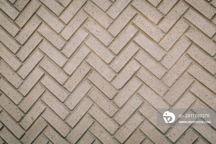 a herringbone pattern brick wall in a neutral beige brown color