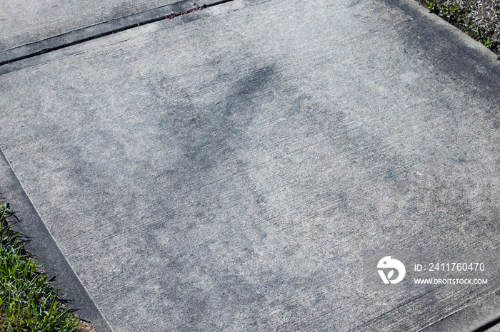 Dirty cement sidewalk in front of a home that needs pressure washing.