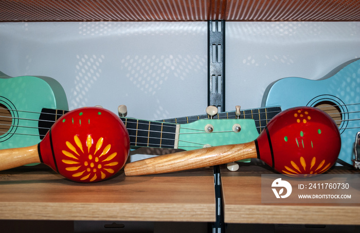 Red maracas and green small Ukulele guitar in music store