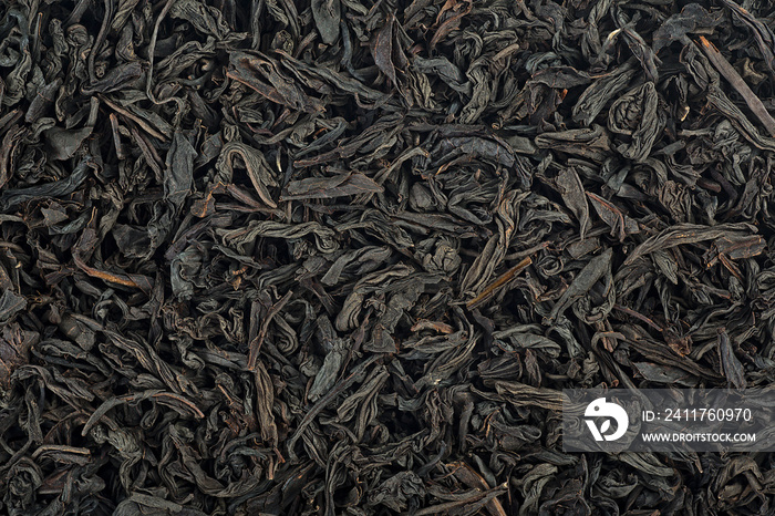 Large dry leaves of black tea. Black tea background. Black tea texture.