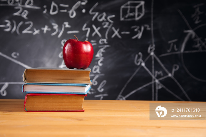 apple on books with blackboard background