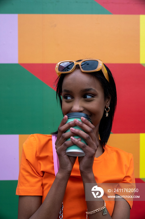 Young woman drinking take-out coffee outdoors