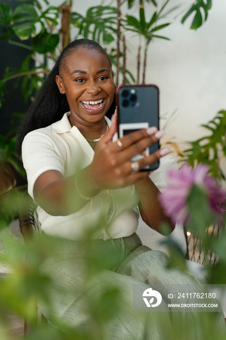 Happy woman with smartphone sitting in office lounge