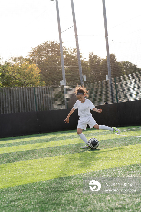 Girl (6-7) playing soccer on soccer field