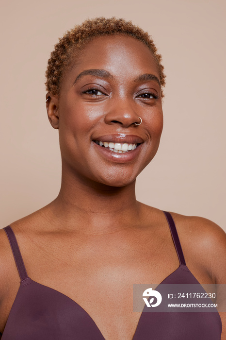 Studio portrait of smiling woman wearing bra