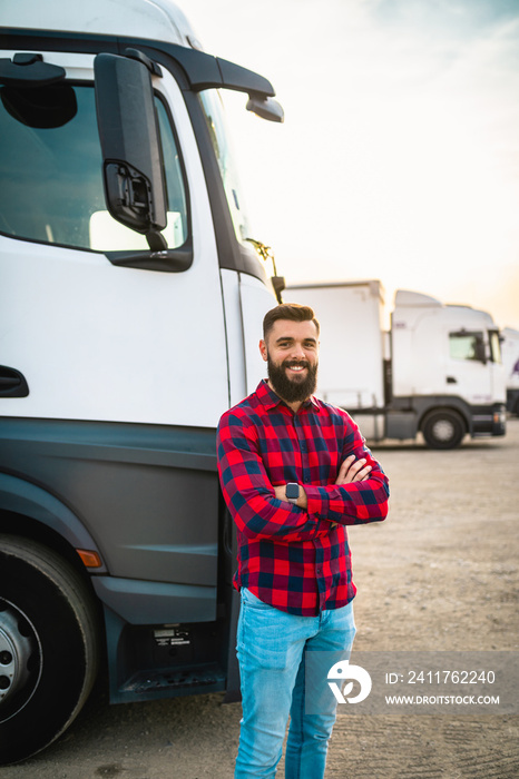 Portrait of young bearded man standing in front of his truck.