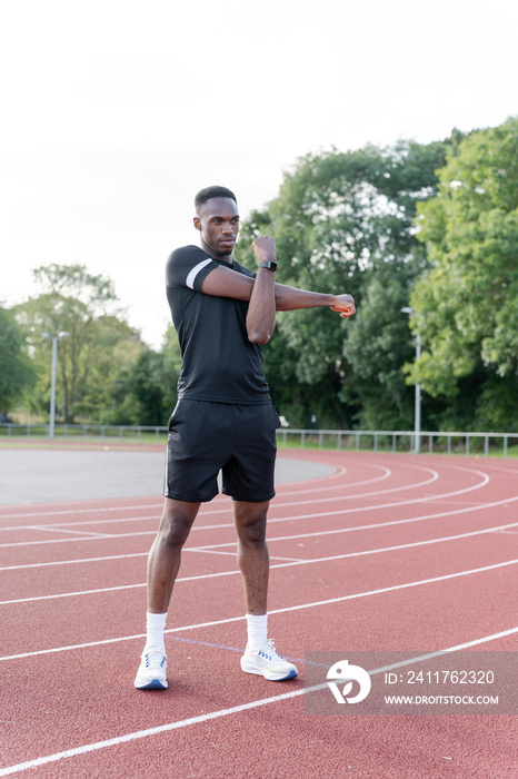 Athlete stretching before training at sports track