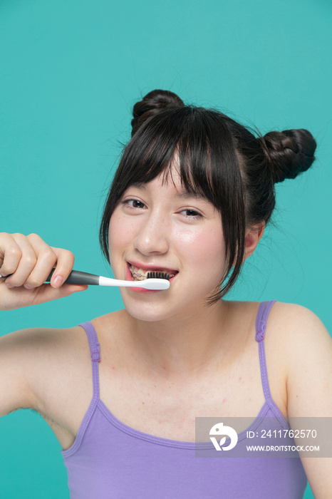 Studio portrait of girl brushing teeth