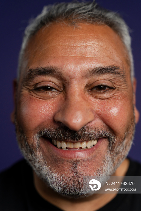 Portrait of smiling man against purple background