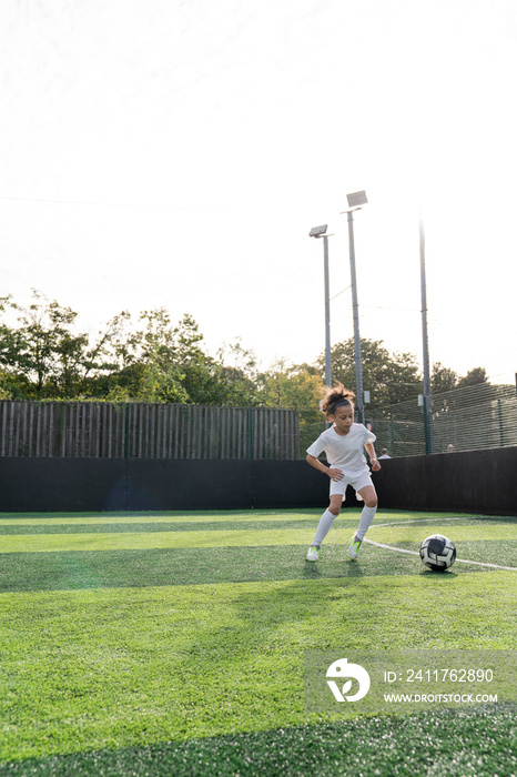 Girl (6-7) playing soccer on soccer field