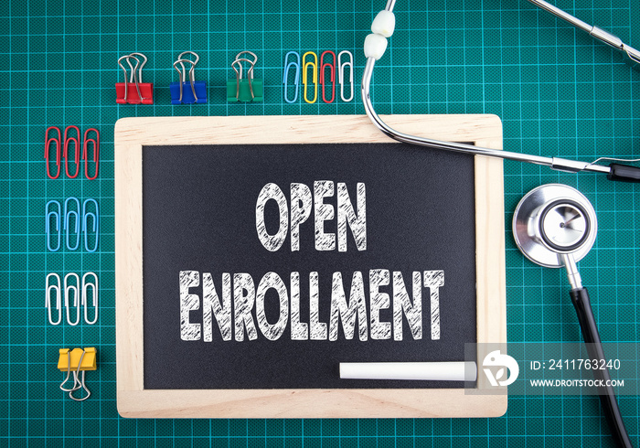 Open Enrollment concept. Medical and health background. Work desk with stationery and stethoscope.