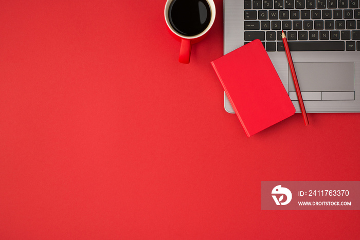 Top view photo of red closed reminder pencil on laptop and cup of coffee on isolated red background with copyspace