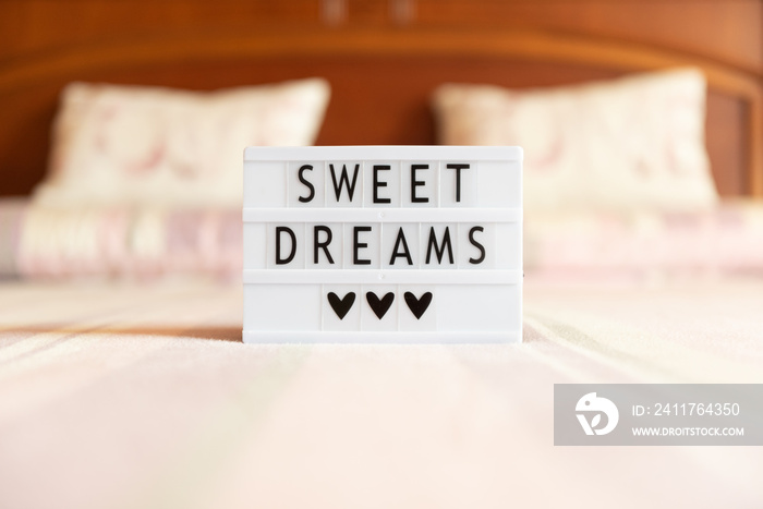 Lightbox with text: sweet dreams, on the bed.