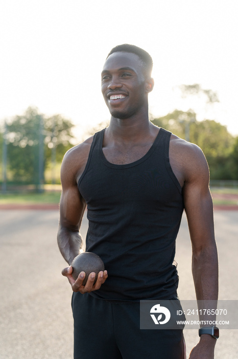 Portrait of athlete holding shot put