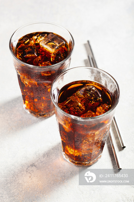 glass of cold cola soft drink with ice on wooden background